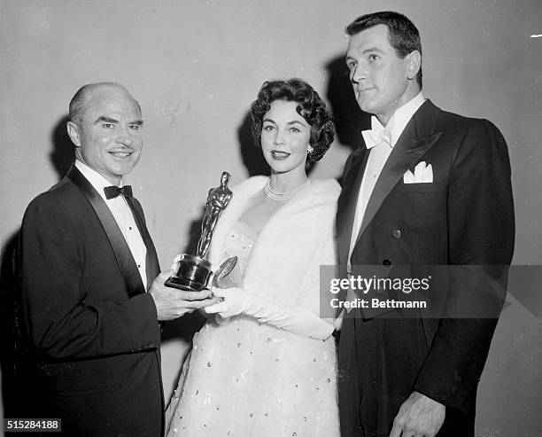 Jennifer Jones, substituting for Elizabeth Taylor, presents an Oscar to John Burton, left, for the best short subject at the 30th annual academy...