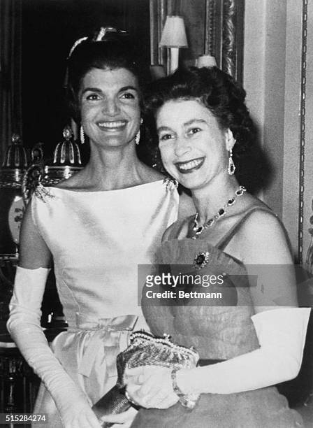 Queen Elizabeth flashes a radiant smile as she stands next to Mrs. Jacqueline Kennedy after dinner at Buckingham Palace here June 5th. The U.S....