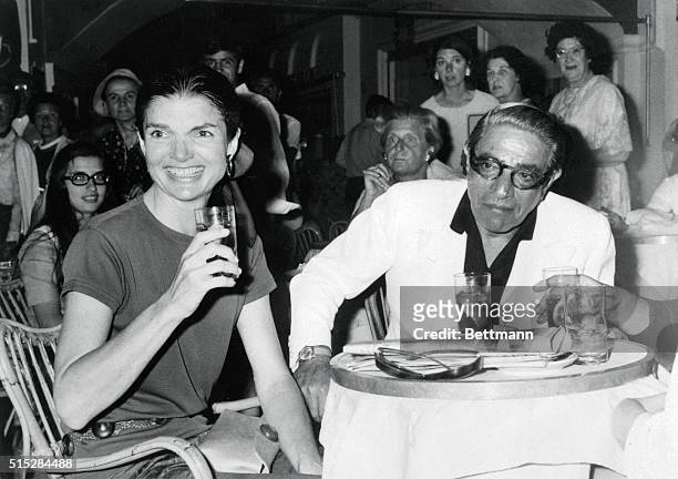 Jacqueline Onassis and her husband, Aristotle, have a drink at a cafe 6/23. The couple is on a cruise of the Mediterranean.