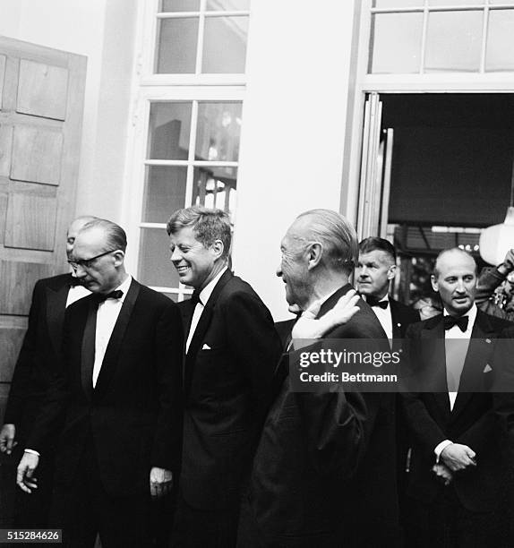 Chancellor Konrad Adenauer ushers U.S. President John F. Kennedy into dinner during is twelve day European tour.