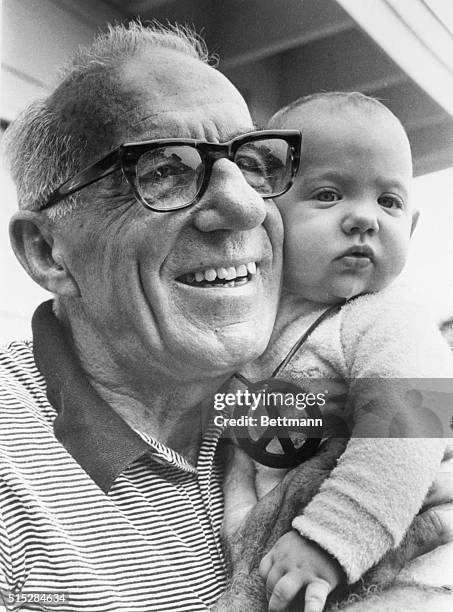 American pediatrician Benjamin Spock holds young Rachel Wilson, 11th July 1969.