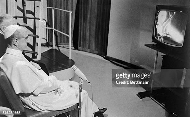 Pope Paul VI sits before a television set in his summer villa here July 20th and watches the astronauts Neil Armstrong and Buzz Aldrin land on the...
