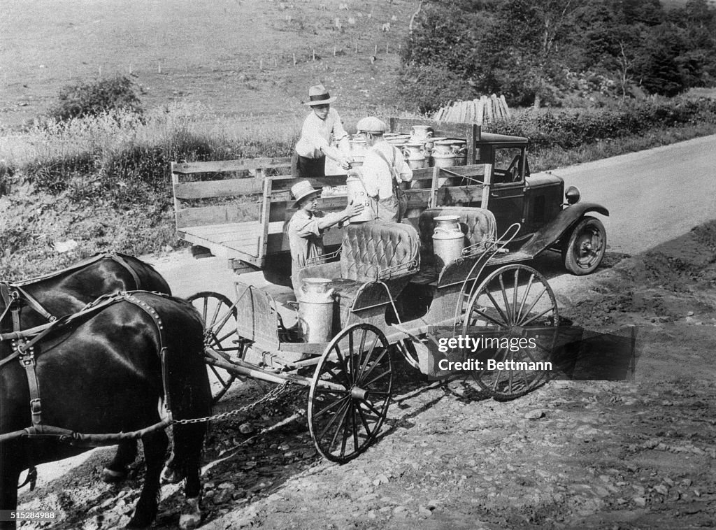 Farmers Handing Milk Cans to Delivery Driver