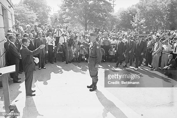 Brigadier General Henry V. Graham, officer in charge of federalized Alabama National Guard units, salutes Alabama Governor George C. Wallace at the...