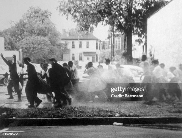 Group of African American anti-segregation demonstrators run for safety as they are sprayed with high-pressure water from fire hoses during a civil...