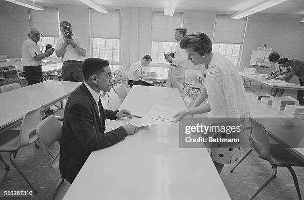 Faculty member at the University of Alabama extension center here helps David McGlathery with his registration forms as the Negro successfully...