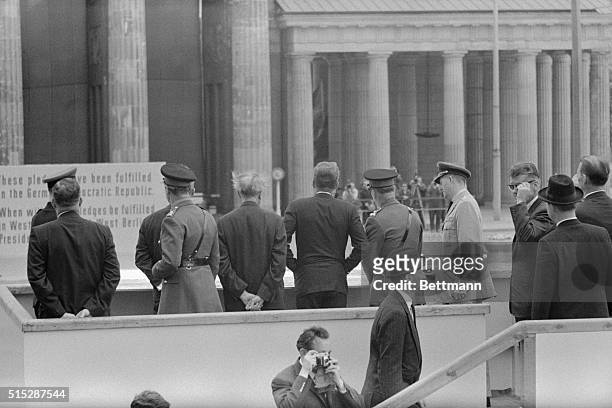 Gets look at wall. Berlin:President Kennedy , accompanied by German Chancellor Konrad Adenauer and an British Berlin Commandant Maj. Gen. David Peel...