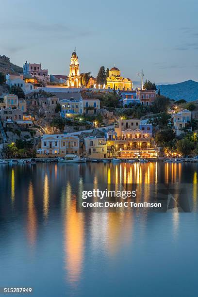 view across the harbour at dusk, gialos, symi - symi ストックフォトと画像