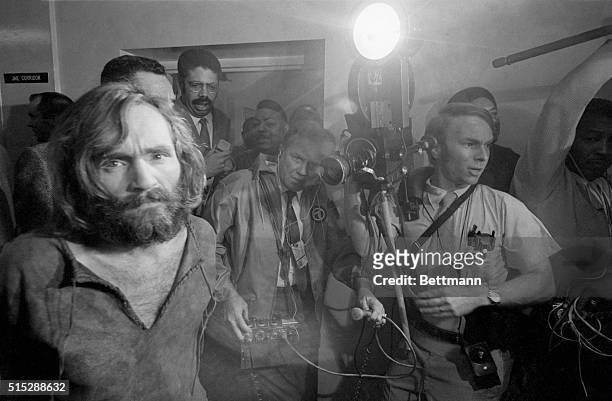 Cameramen film the scene as Charles Manson is brought into the Los Angeles city jail under suspicion of having masterminded the Tate-LaBianca murders...