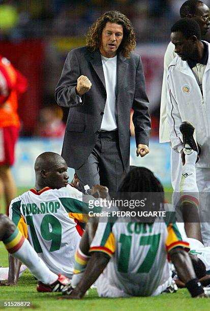 Senegal's coach Bruno Metsu of France pumps his fist as he talks to midfielder Papa Bouba Diop and defender Ferdinand Coly during a break before...