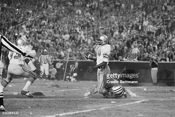 New York: Ken Houston, , of the Houston Oilers fails to his knees as he is grabbed around the ankles by Don Maynard of the New York Jets after...
