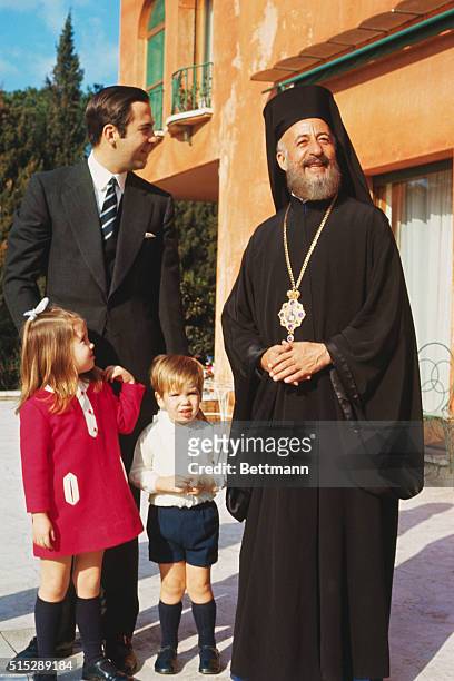 Greek Archbishop Makarios visits self-exiled King Constantine of Greece and his family at their Rome villa. King Constantine, with children, Princess...