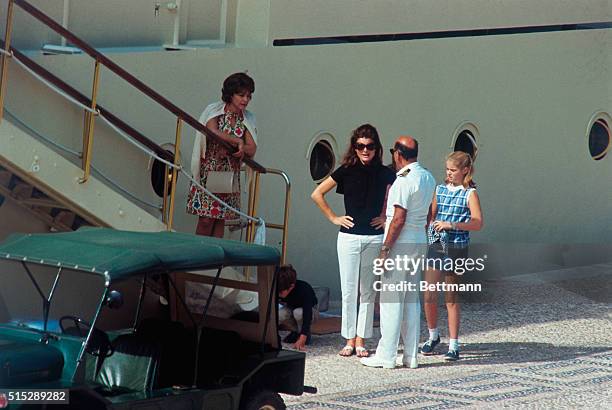 Jacqueline Kennedy, widow of president John F. Kennedy, stands with their children John Jr. And Caroline next to Caroline, the yacht belonging to...