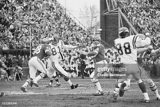 Chiefs Len Dawson getting ready to throw the ball as his teammates hold off Vikings Alan Paige and Carl Ellen at Super Bowl IV. The Kansas City...