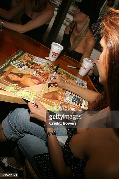 Michelle signs her calender picture during the Hooters girls calendar signing event at Hooters restaurant October 21, 2004 in New York City.