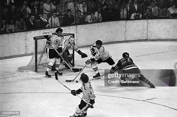 All eyes are on Bruins defenseman Bobby Orr as he takes puck past Buins goal while Ranger Pete Stemkowski tries to shake it away from him during...