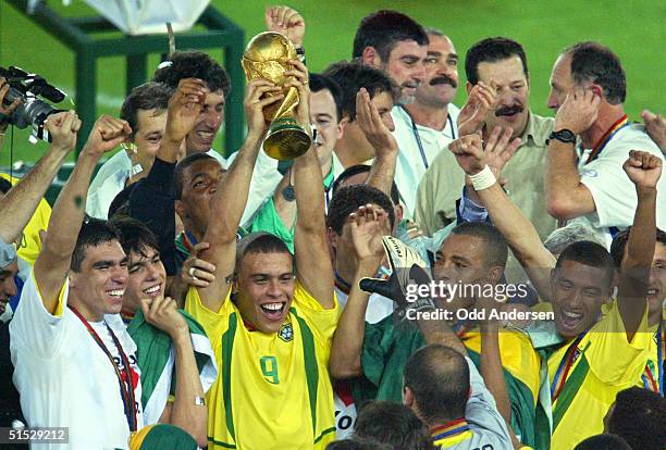 Brazil's forward Ronaldo , flanked by teammates, hoists the World Cup trophy during the award ceremony at the International Stadium Yokohama, Japan,...