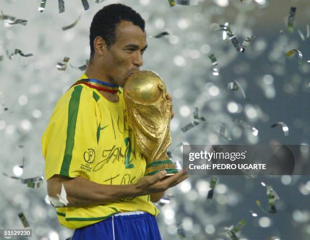 Brazil's team captain and defender Cafu kisses the World Cup trophy, celebrating Brazil's 2-0 victory over Germany in match 64 of the 2002 FIFA World...