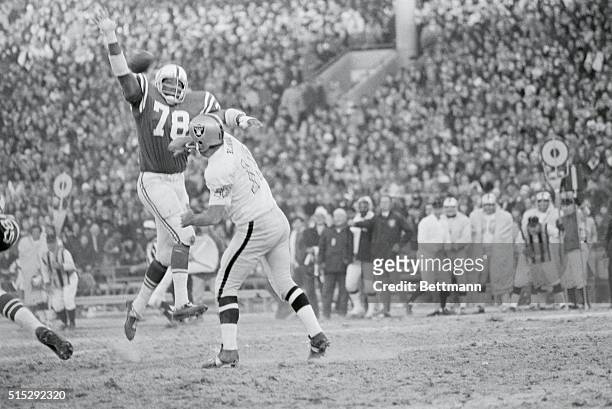 Championship. Baltimore: Raiders' back up quarterback George Blanda completes a pass for a first down over the raised arms of Colts' Bubba Smith in...