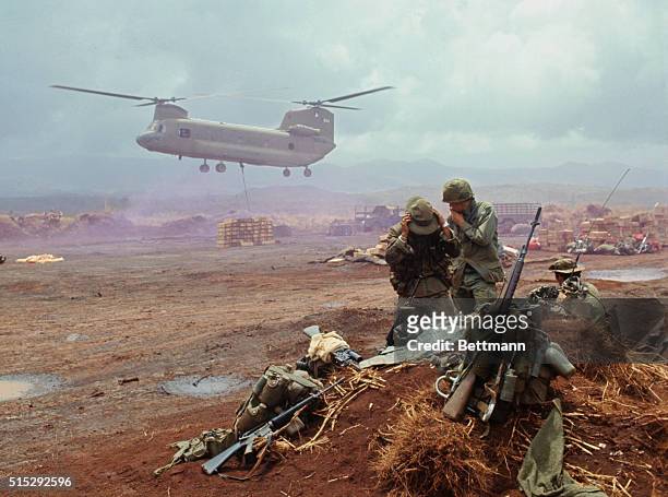 Khe Sanh, S. Vietnam: U.S. Chinook helicopter lowers supplies by cable sling onto field as GI's avoid airstream created by rotor blades.