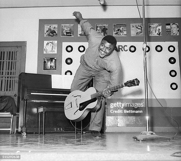 Guitar in hand, New York Giant football star, Roosevelt Grier, of Linden, N.J., frolics in a studio of the American Recording Company. He recently...