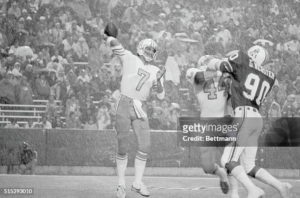 Houston Oilers--Patriots. Foxboro, Massachusetts: Oilers quarterback Dan Pastorini, , looks for a receiver in the pouring rain as teammate Fred...