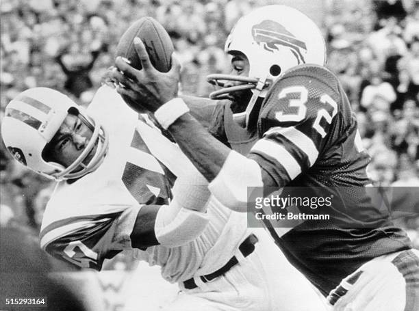 Simpson , of the Buffalo Bills, snares a pass from quarterback Joe Ferguson, while the New York Jets' Roscoe Ward attempts to wrestle the ball away...