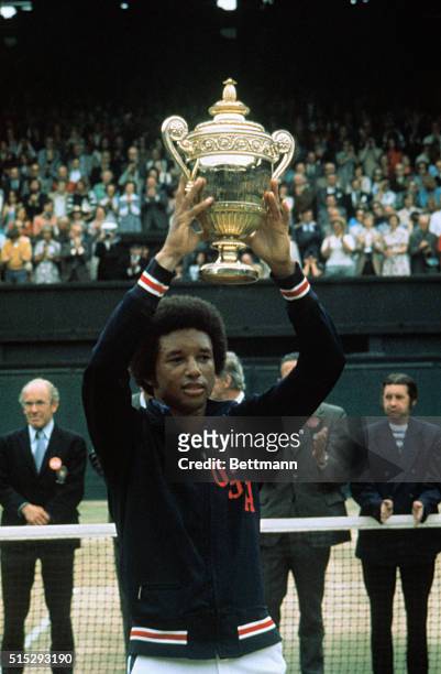 Arthur Ashe holds up his Wimbledon trophy after defeating Jimmy Connors in the Men's Singles championship 6-1, 6-1, 5-7, 6-4.