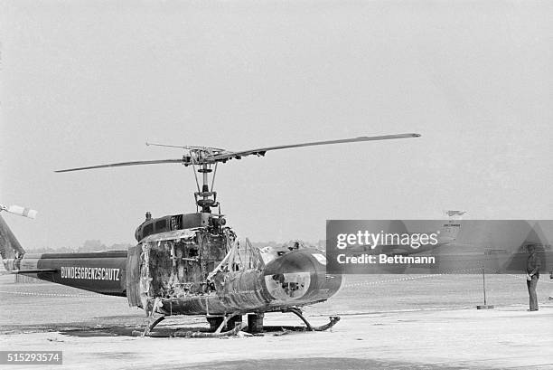 The shell of a helicopter destroyed by a terrorist's grenade sits at Fuerstenfeldbruck Air Base as the plane carrying the body of murdered...