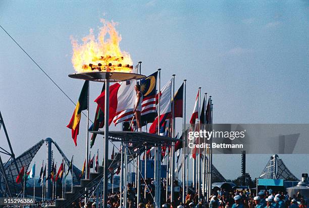 Munich, Germany. With a backdrop of flags and a roaring flame overhead, Gunter Zahn pauses after lighting the Olympic flames signifying the opening...
