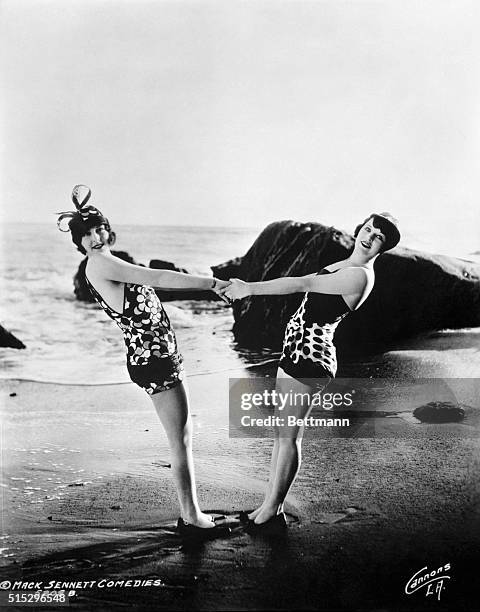 Bathing beauties hold hands on a beach in a Mack Sennett comedy. An undated photograph.