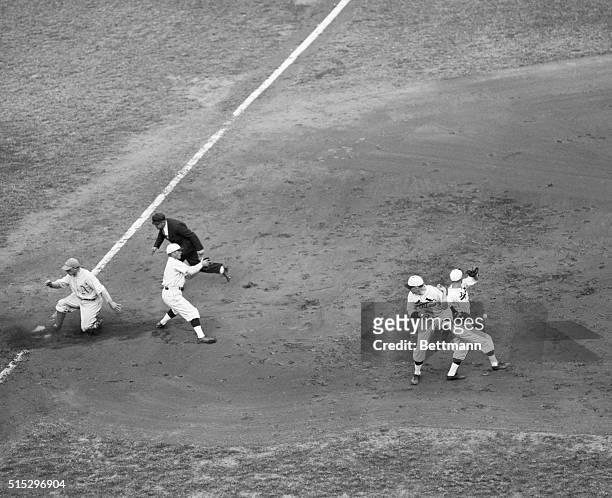 St. Louis, MO: As two St. Louis Cardinal infielders fight it out to determine who shall throw the ball to third base, Jimmy Dykes of the Philadelphia...