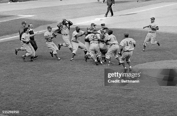 New York, NY: Dodgers rush to the mound to embrace young southpaw Johnny Podres after he hurled the final ball in today's 2-0 victory over the Yanks....
