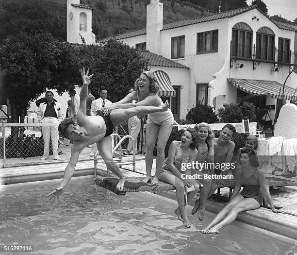 Santa Monica, CA- Mickey Rooney goes off the diving board, as Marjorie Gestring gives him a push, during Judy Garland's birthday party at Louis B....