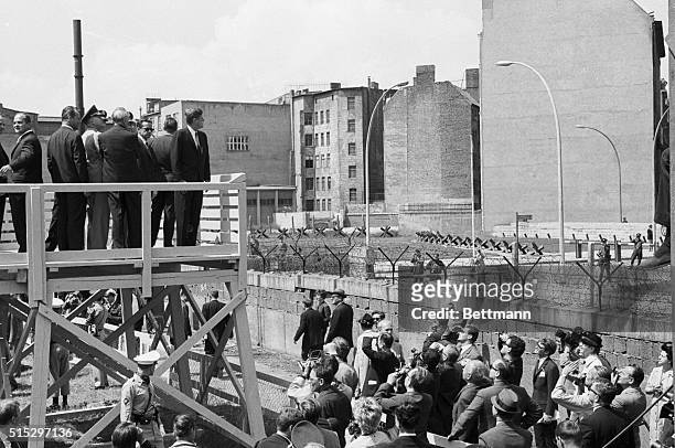 President John F. Kennedy stands on a platform overlooking the Berlin Wall during his visit to West Berlin.