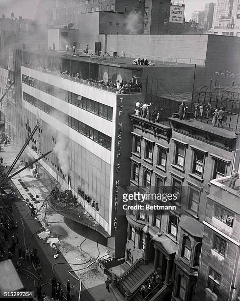 New York, NY- Persons trapped in the upper floors of the building when fire broke out in the Museum of Modern Art are shown here climbing down from...