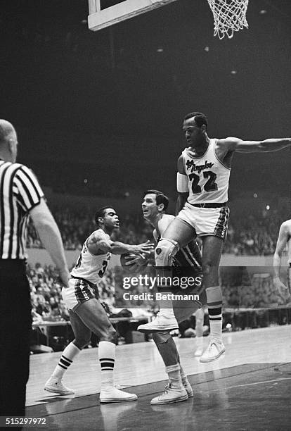 Los Angeles, CA: Jerry Lucas of the Cincinnati Royals drives in for a shot as Elgin Baylor and Tom Hawkins of the Los Angeles Lakers tries to stop...