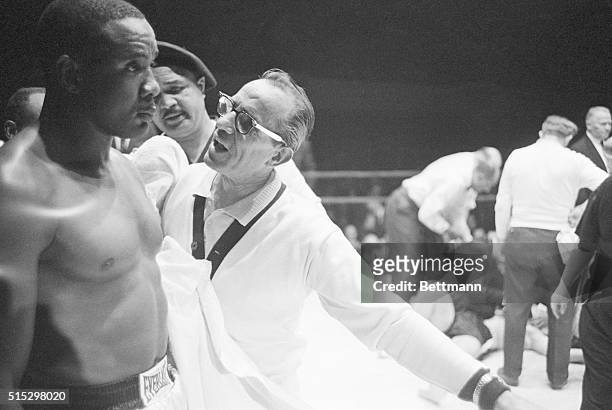 Philadelphia, PA- Heavyweight Sonny Liston stares blankly as his handler yells to him that the fight is over and "we won," Dec. 4. The fight ended...