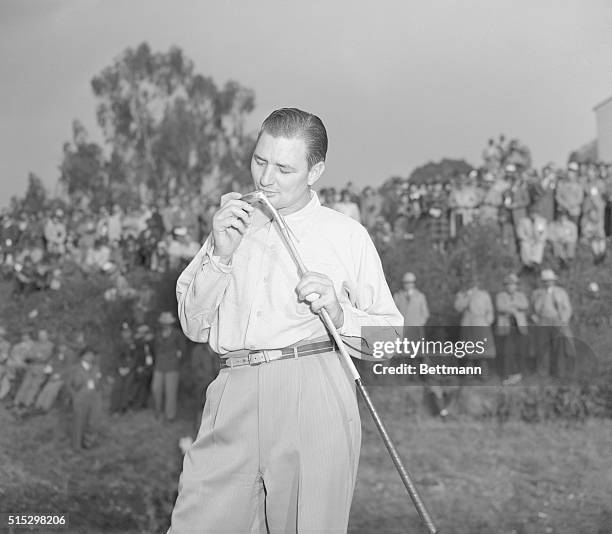 Los Angeles, California- Harold "Jug" McSpaden bestows a fond kiss on the putter which gave him victory in the 1944 Los Angeles Open Golf Tournament....