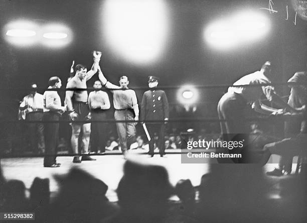 Referee Hank Lewis raises the arm of boxer Primo Carnera as he declares him the winner in his match against Pat McCarthy.