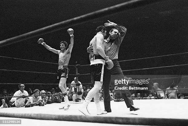 New York, New York- Carlos Monzon of Argentina smiles and raises his arms in victory as referee Tony Perez holds onto challenger Tony Licata and...
