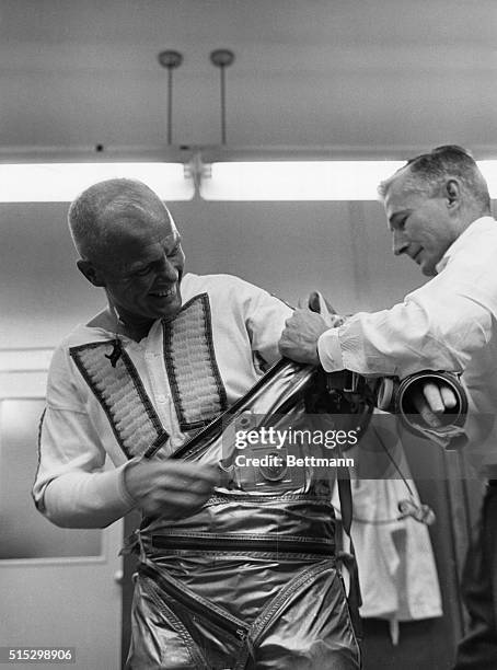 Cape Canaveral, FL-Astronaut John Glenn smiles happily while he is assisted by suit technician Joe Schmitt in preparing for the Mercury-Atlas 6...