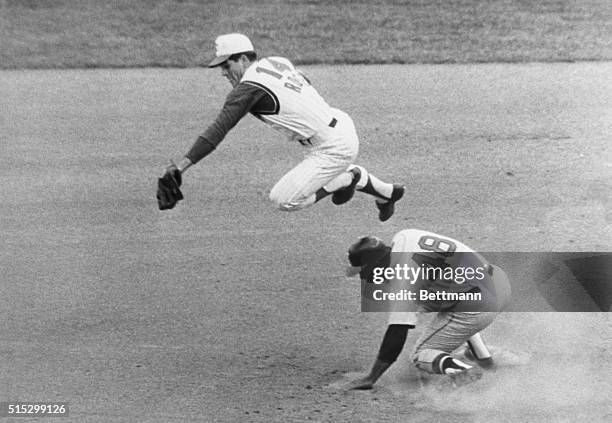 Cincinnati Reds infielder Pete Rose leaps over Mack Jones of the Milwaukee Braves, snagging a high pickoff attempt by Reds pitcher Jim O'Toole.