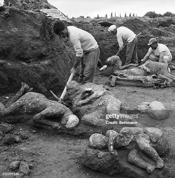 Naples, Italy - Archaelogical workers extract the mummified bodies of two adults and three children from earthen mold here May 1st. These bodies are...