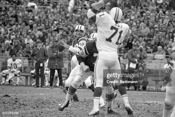 New York, NY: Despite the menacing hulk of the New England Patriots' Art May looming up before him, New York Jets' quarterback Joe Namath gets set to...