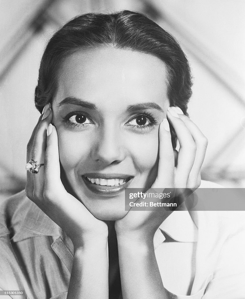 Young Anna Kashfi Smiling with Head in Hands