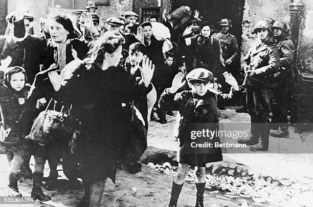 Warsaw, Poland-Arms raised above their heads, white faces with fear. A group of Polish women and children waits to be led off by storm troopers...