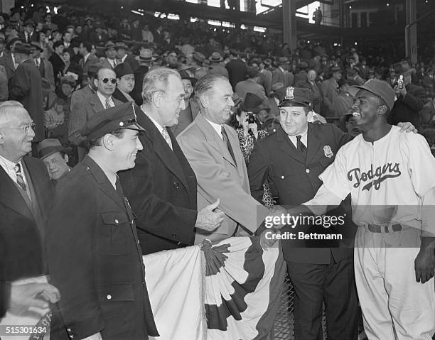 Brooklyn, NY-Jackie Robinson, the first Negro to win a place on a major league baseball club, is shown being congratulated by former Senator James...