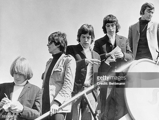 English singing sensations The Rolling Stones are shown as they leave an airplane. Left to right: Brian Jones, Keith Richards, Mick Jagger, Bill...