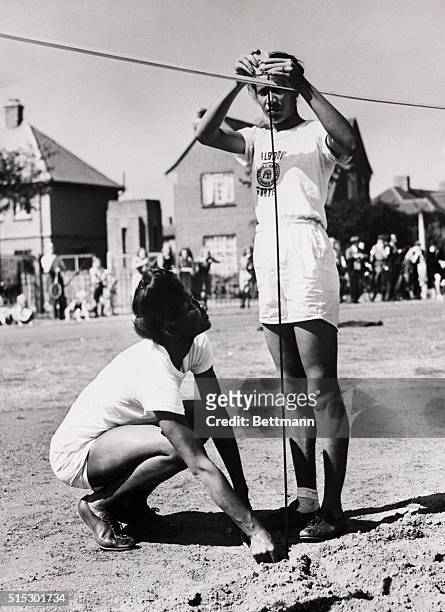 London, England-Emma Reed , of Tennessee and Alice Coachman of Georgia , members of the U.S. Olympic team are shown as they continued to keep in...